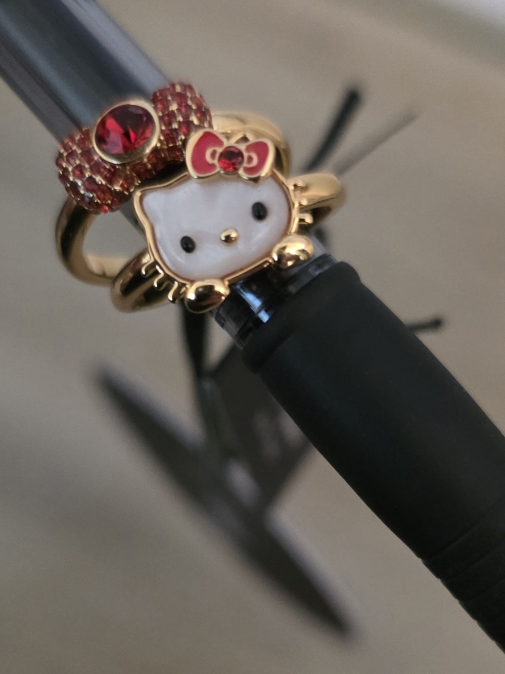Hello Kitty x kate spade gold and red charm rings.